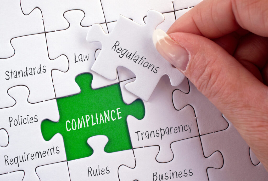 Puzzle pieces representing workplace compliance, including safety, quality, environmental, and legal elements, with the final piece labeled ‘Regulations’ being placed.