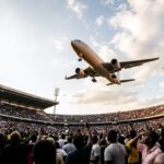 Illustrative image of a commercial jet flying low over a crowded stadium, representing AOAL's commentary on the SACAA investigation into Airlink's low-altitude flyover at a Springboks vs All Blacks match